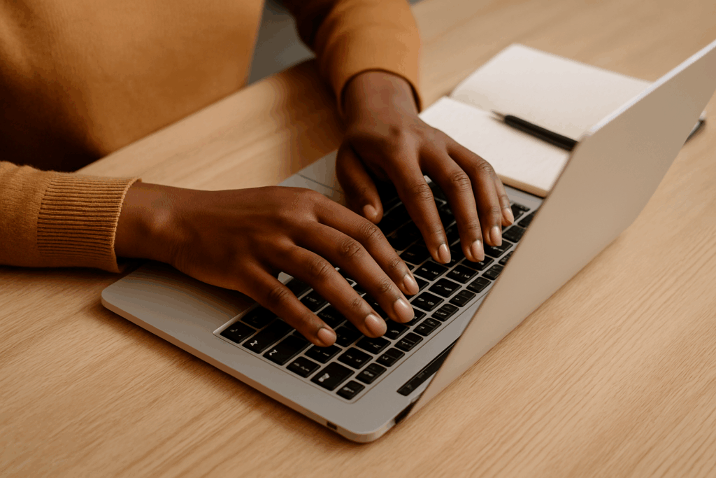 black female hands typing on laptop